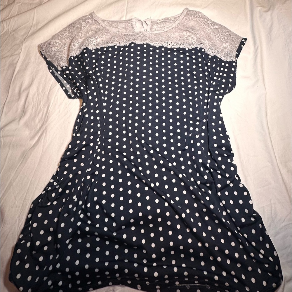 Cute casual poke dot navy blue blouse with a a bow on the back.